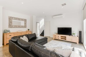 Large open living area with TV, dining and kitchen