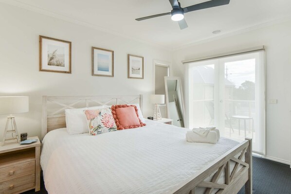 Upstairs master bedroom with king bed, TV and ensuite bathroom and balcony