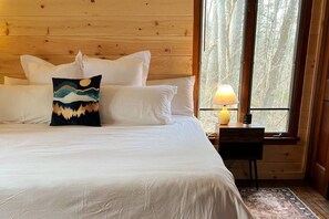 Bedroom 1 has a King size bed, two large windows, a small closet, storage and a 55" TV