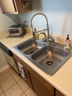 New kitchen faucet at the kitchen sink and toaster.