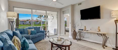 A large sliding glass door opens onto the fully screened lanai, filling the space with sunlight.