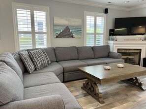 Cozy living room with fireplace, smart HDTV with surround sound.