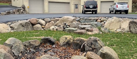 Huge firepit with detailed landscaping in front of house, yet cloaked in privacy