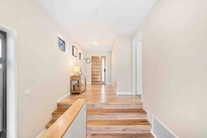Spacious hallway leads to the living space and to downstairs bedrooms & laundry
