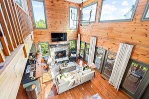 Main level living room with gas fireplace + kitchen + dining area. 