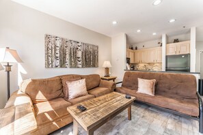 Living area featuring a gas fire place, mounted smart TV, and beautiful views of the lake and mountains out the window.