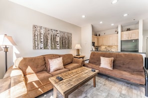 Living area featuring a gas fire place, mounted smart TV, and beautiful views of the lake and mountains out the window.