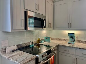 Kitchen - This beautiful kitchen offers custom cabinetry that is full of items needed for meal prepping during your stay.