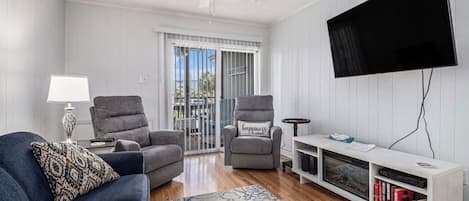 Living room with electric fireplace and 52" television, attached screen porch
