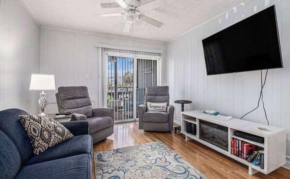 Living room with electric fireplace and 52" television, attached screen porch