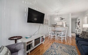 living room, electric fireplace, television, dining area, kitchen and hallway
