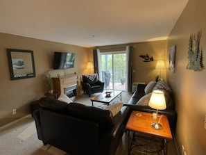 Living room with big screen tv and seating for 6 with patio sliding doors. 