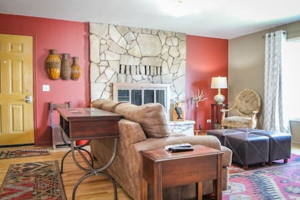 Cozy living room with original hardwood floors, a large picture window, wood burning fireplace and a comfortable couch - great for relaxing!