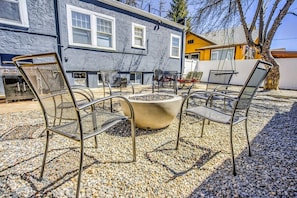 Gather around the fire pit in this inviting shared backyard, complete with plenty of seating, a BBQ grill, and a cozy ambiance.