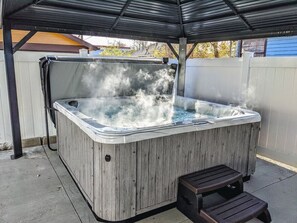 Enjoy a soothing soak in the hot tub, sheltered under a gazebo with ambient lighting—your perfect spot to relax and recharge..
