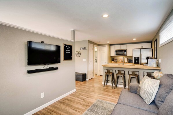 Bright and modern open-concept studio with a cozy seating area, Smart TV, and a fully stocked kitchen—perfect for work or relaxation!