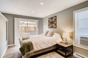 Drift into comfort on a plush queen bed with premium bedding, natural light, and private patio access for a peaceful retreat..
