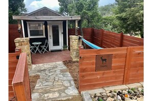Studio cabin with private fenced yard with hammock and sitting area.
