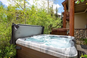 Private hot tub on first level with deck above that has a grill and a small table perfect for morning coffee.