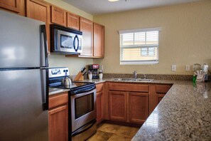 Fully equipped kitchen with stainless appliances and granite countertops.
