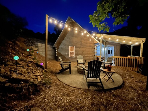 The string lights over the firepit glow brightly at night.