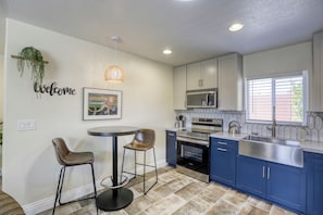 Dining area with bistro table & chairs lit by pendant light