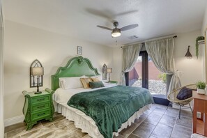Bedroom with king bed and sitting area with french doors opening to patio