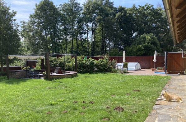 The fenced in yard includes the pool and a hot tub, and a door out to the meadow