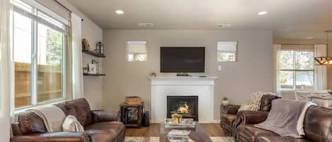 Gather in the spacious living room with a cozy gas fireplace and lots of natural light