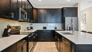 Cook up culinary delights in this sleek kitchen! Stainless steel appliances, granite countertops & a breakfast bar await your meals.