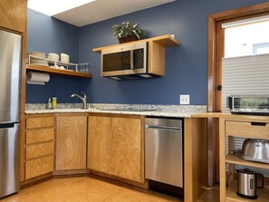 Fully equipped kitchen has fridge, freezer, stovetop, microwave and dishwasher. 