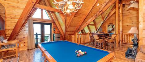 The upstairs loft space has a pool table, game tables, and own balcony with amazing view