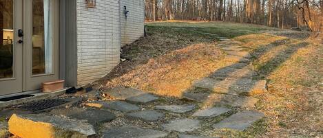 Entry door to efficiency. Stones lead up to driveway where car is parked