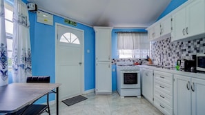 View of kitchen with small dining table and entrance door