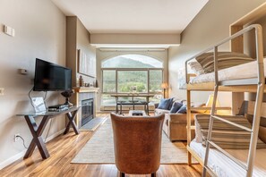 Living room area featuring vaulted ceiling, flat screen TV, gas fireplace, access to the private balcony and gorgeous views overlooking Keystone Lake.