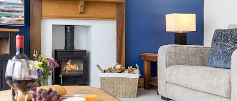 Lounge with a 3 seater sofa, 2 cosy armchairs, Smart TV and log burning stove.