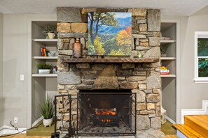 The gorgeous stone fireplace includes an electric fire with flames, heat, or both. Art: "Deciduous Forest in Autumn, Blue Ridge Parkway, North Carolina"