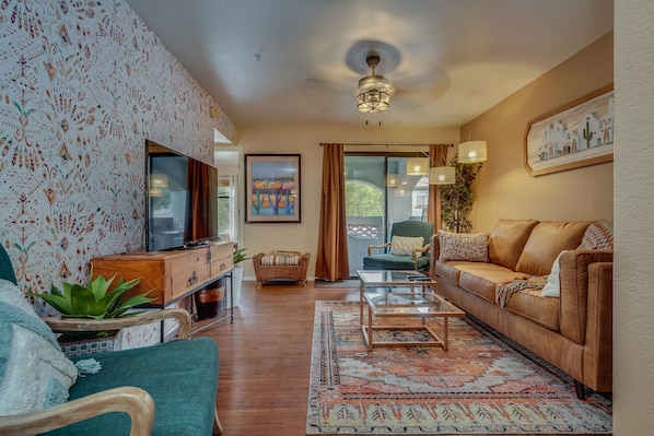 View from front door of living room with comfortable sofa and breezy ceiling fan