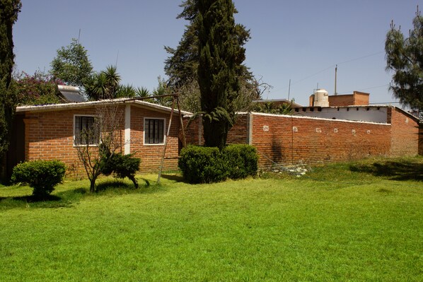 Vista de la casa desde jardín trasero. Se aprecia calentador solar en la azotea.