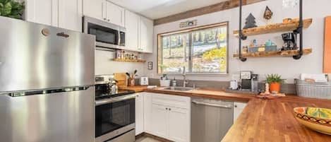 Modern kitchen with microwave, dishwasher, stove, fridge & garbage disposal