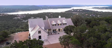 Drone view of front of house with Lake Travis in the back