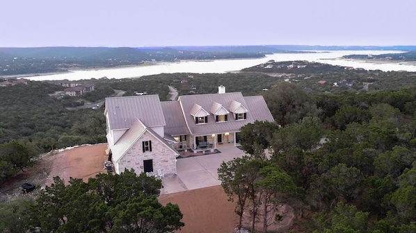 Drone view of front of house with Lake Travis in the back