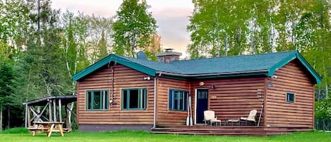 Back of Au Sable River Cabin. Large grassy area leads to the river. 