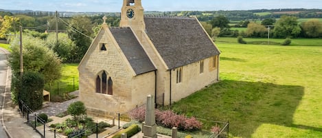 Restored exterior has views over farmland and Cotswold hills.