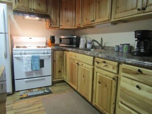 A modern kitchen stocked with all culinary items necessary for food preparation.