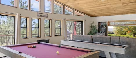 Main area features an with 86" TV, pool table, shuffle board and dart board.