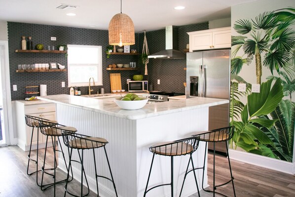 Indulge in a meal at the eat-in kitchen bar in our tropical modern kitchen.
