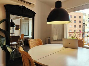 The spacious dining area features a round white table. Natural light that floods in from the large window. The sleek modern design of the furniture adds a touch of sophistication to the room.