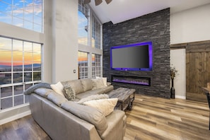 Custom leather sofa with pull out queen bed, 86” Smart TV, linear fireplace, barn doors leading to both East and West Wings of the home.  It's Football time!