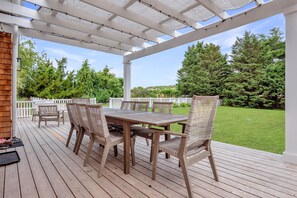 Outdoor dining table with seating for up to 12 on an oversize deck with lounge
